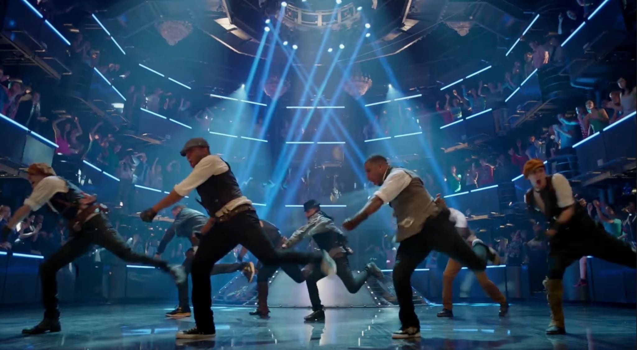 Choreographed performers under blue stage lights